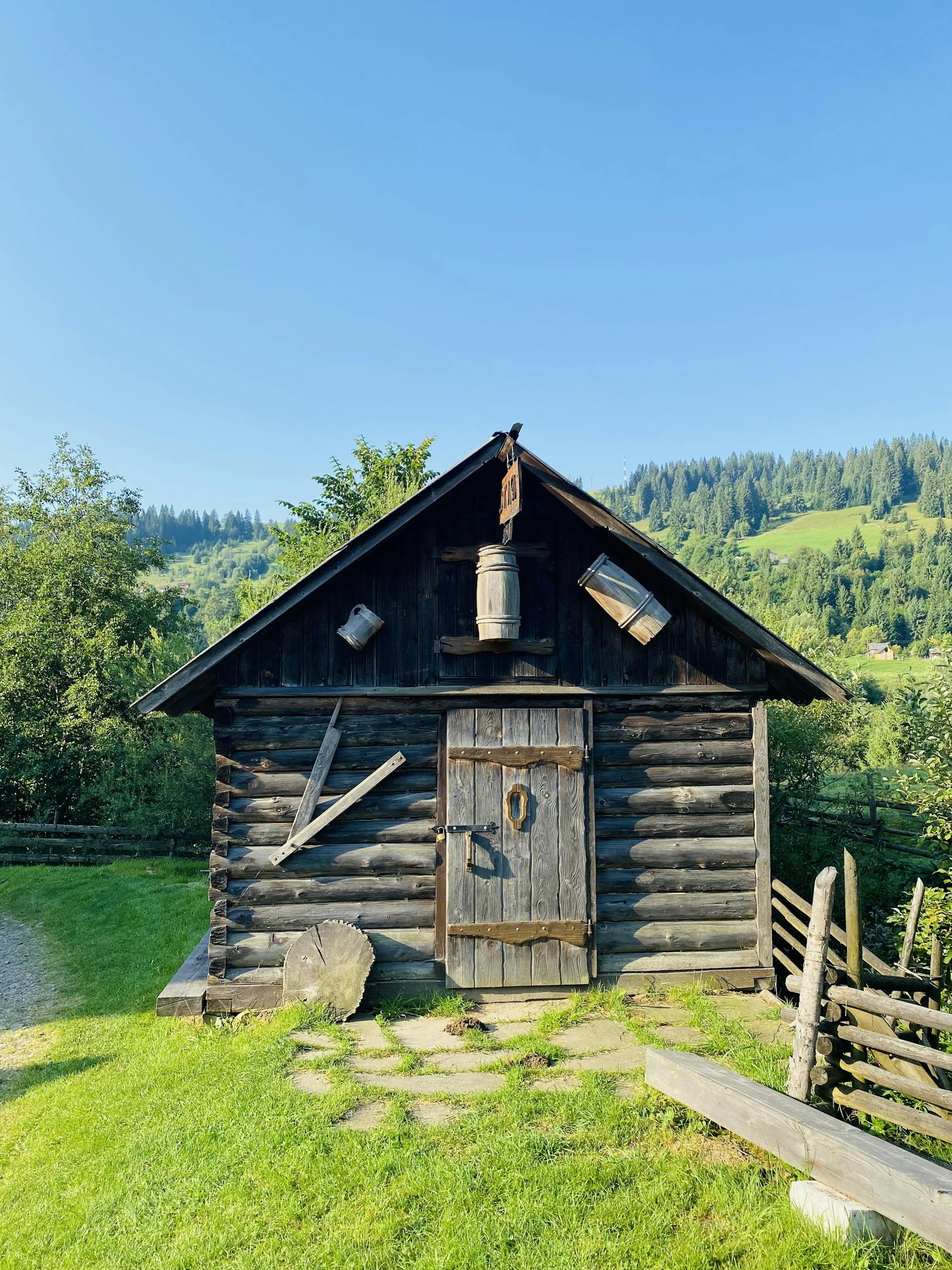 Charming wooden cabin set against a lush green mountain landscape, ideal for rustic retreats.